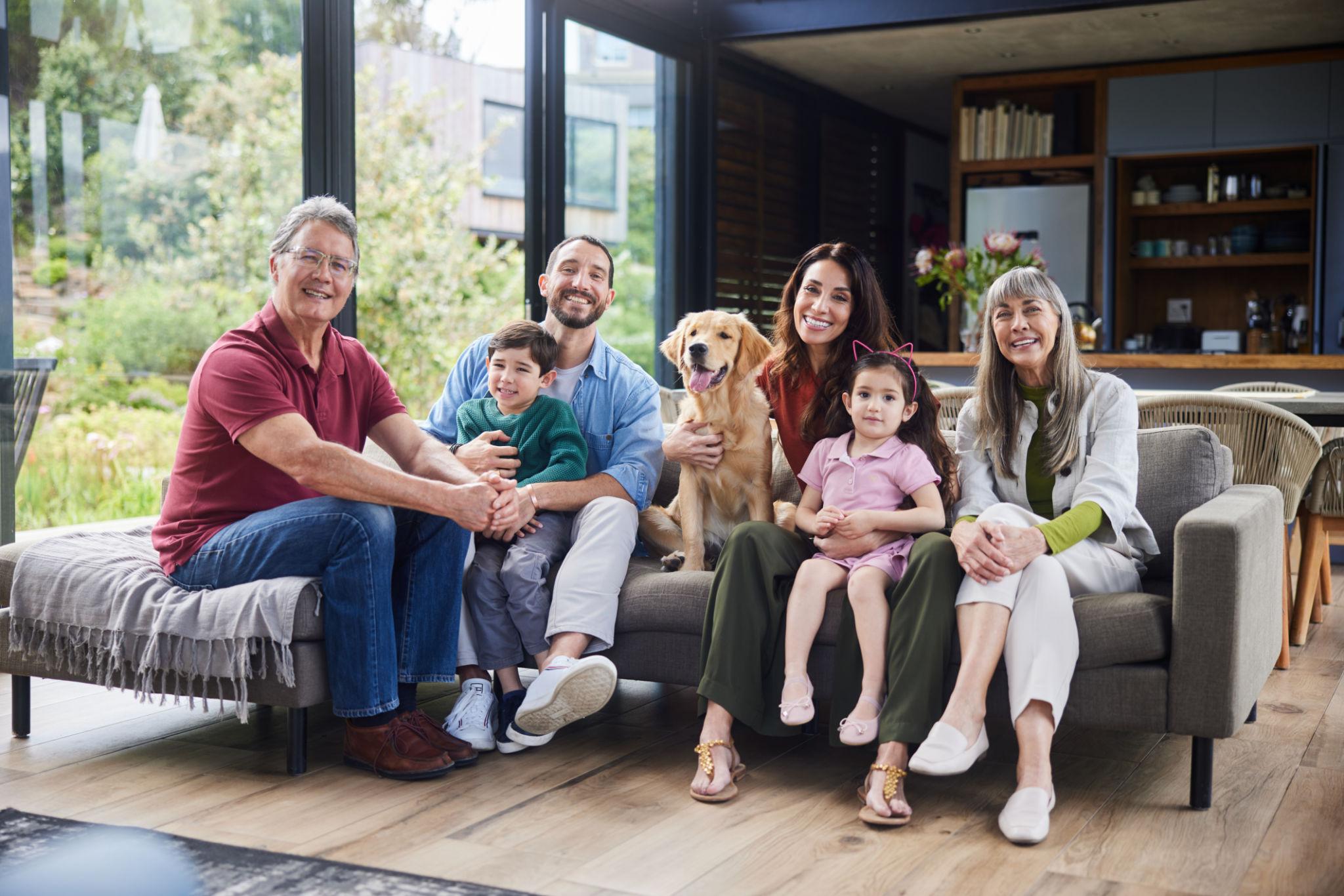 Multi-generational family enjoying quality time with their pet dog in a comfortable pet-friendly living room.